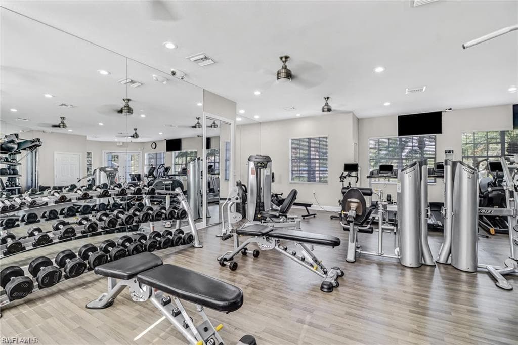 Gym with ceiling fan and hardwood / wood-style flooring