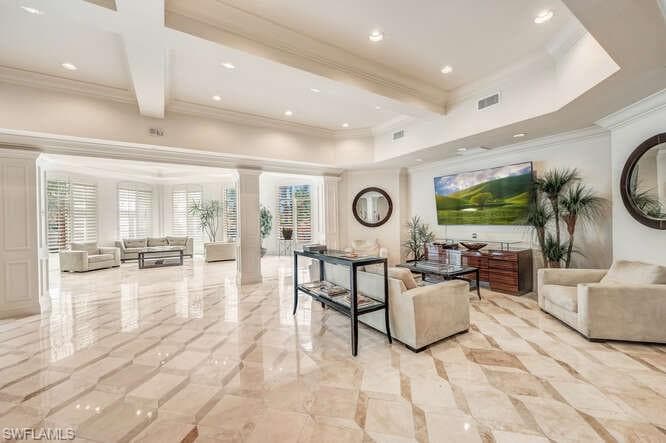 Living room featuring ornamental molding, beamed ceiling, decorative columns, and light tile patterned floors