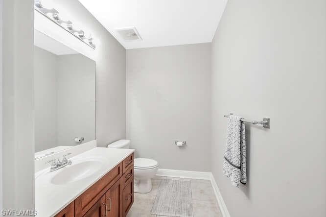 Bathroom with tile patterned flooring, vanity, and toilet