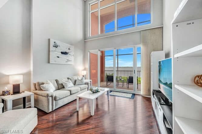 Living room with a towering ceiling and dark hardwood / wood-style floors
