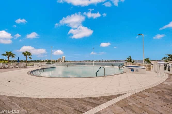 View of pool with an in ground hot tub and a patio