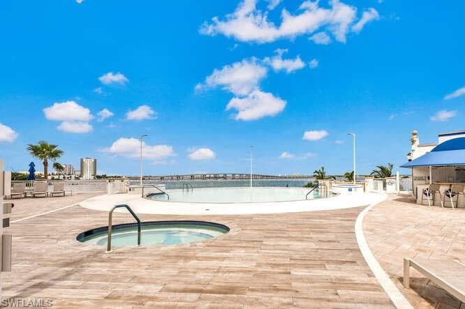View of swimming pool with a community hot tub
