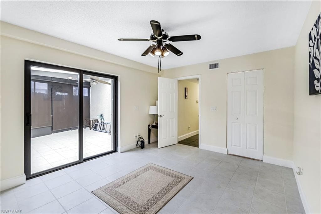 Unfurnished room with ceiling fan and light tile patterned floors