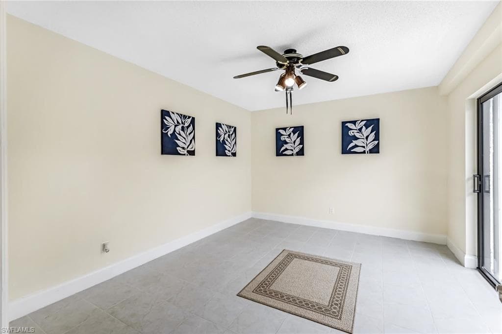Unfurnished room with ceiling fan and light tile patterned flooring
