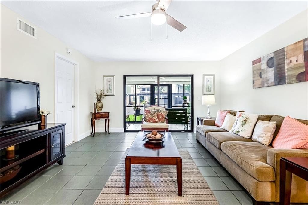 Living room featuring tile patterned flooring and ceiling fan