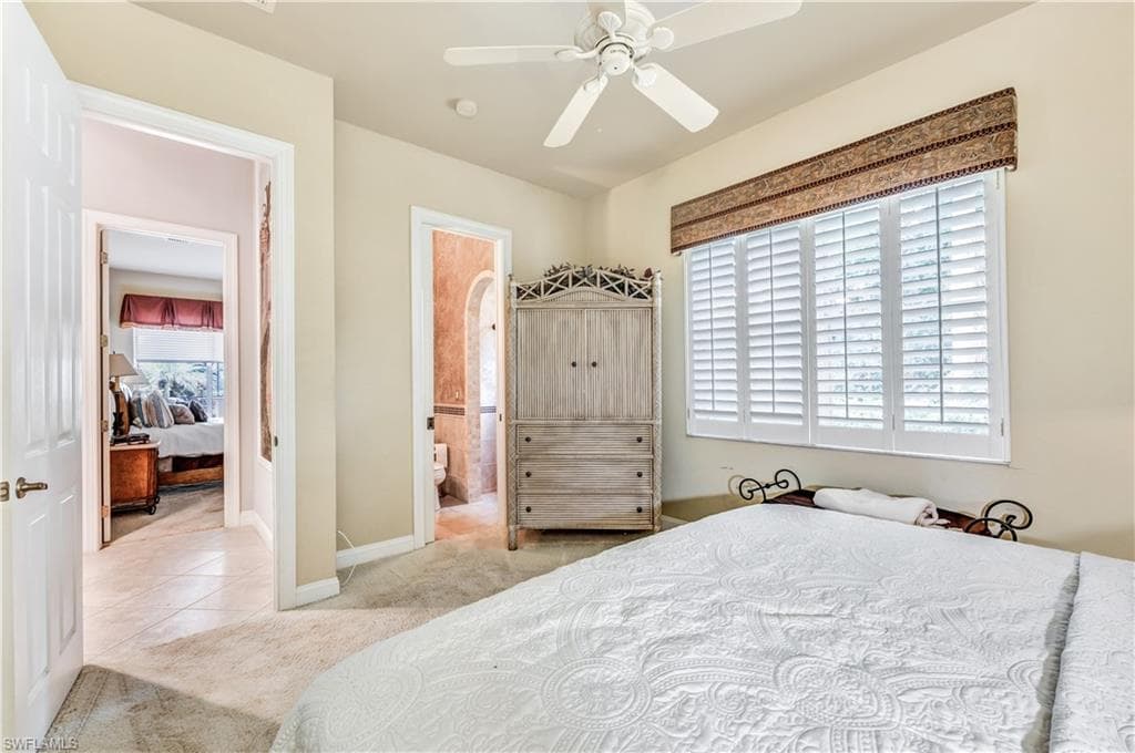 Bedroom with ceiling fan, a closet, multiple windows, and light tile patterned flooring
