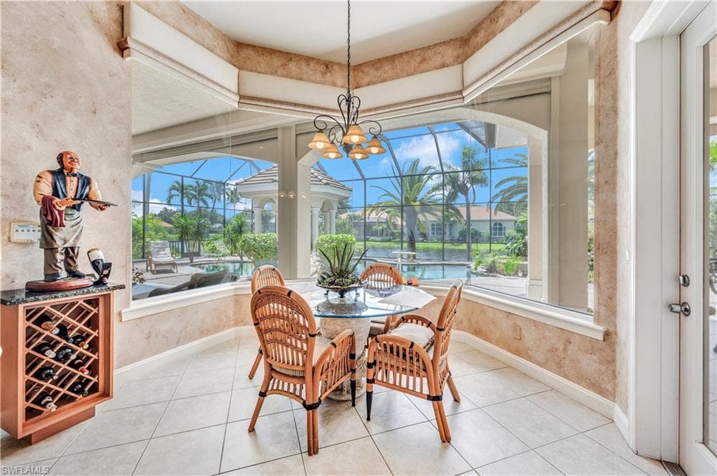 Dining space with an inviting chandelier, light tile patterned floors, and wine cooler