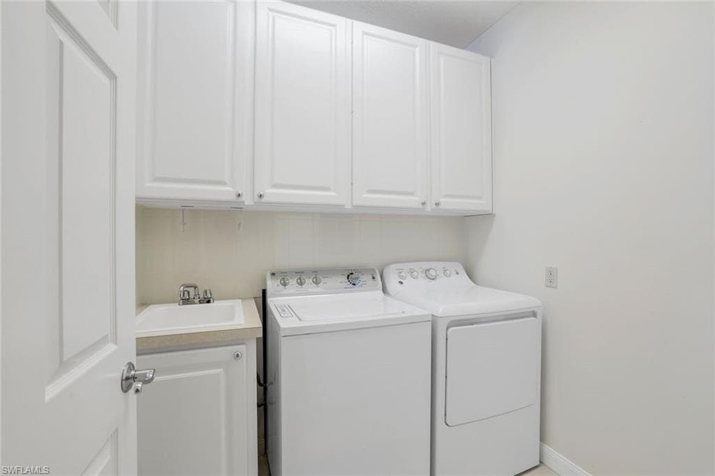 Washroom featuring cabinets, sink, and independent washer and dryer