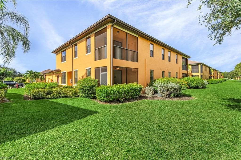 Back of property featuring a lawn