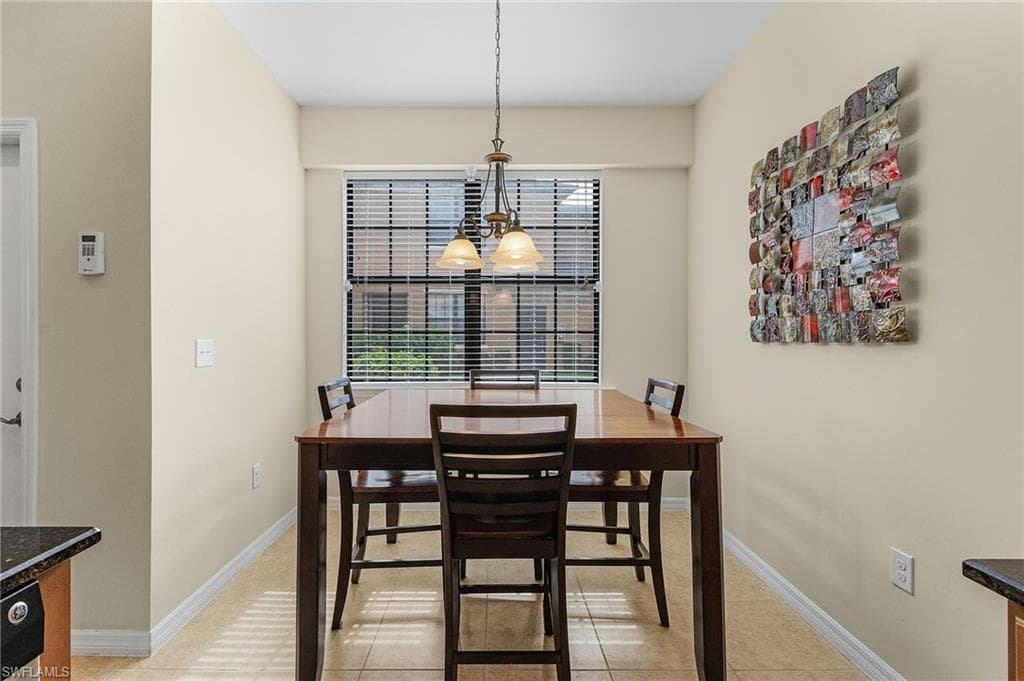 Tiled dining area with a chandelier