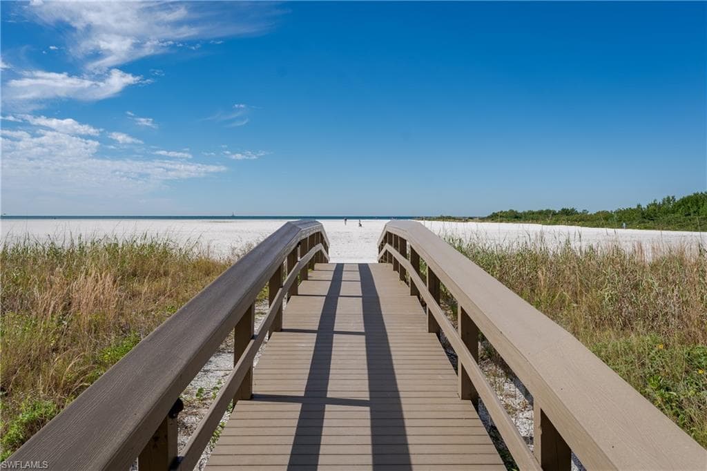View of dock featuring a view of the beach and a water view