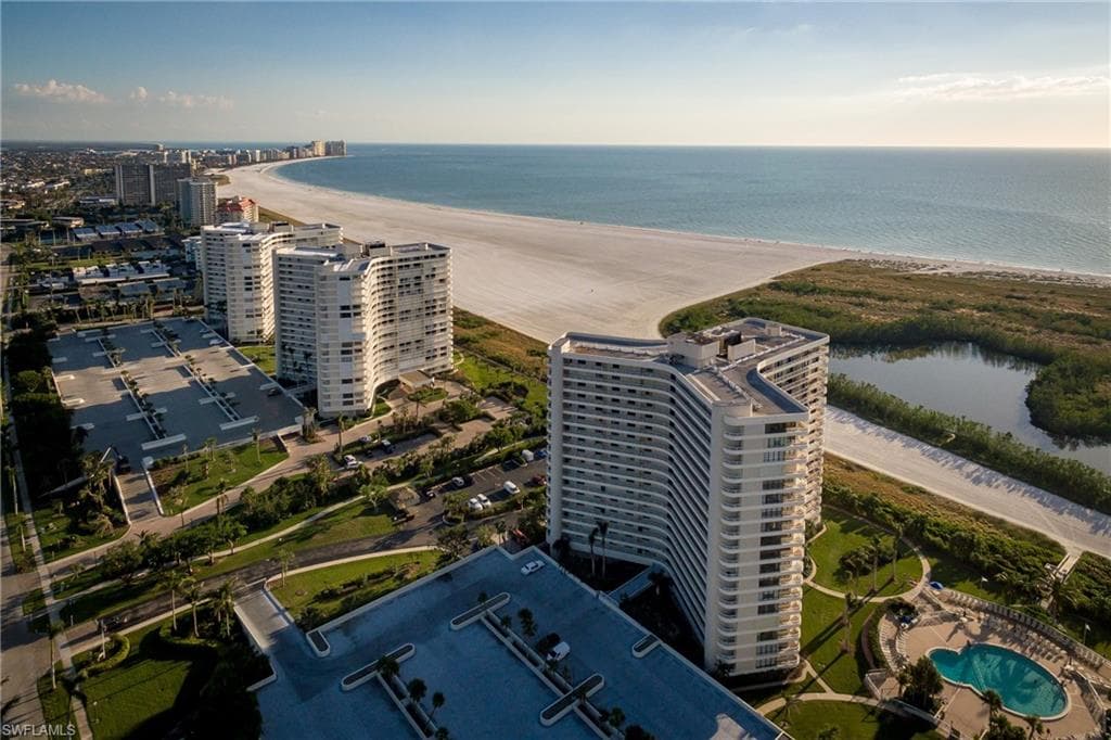 Birds eye view of property featuring a view of the beach and a water view