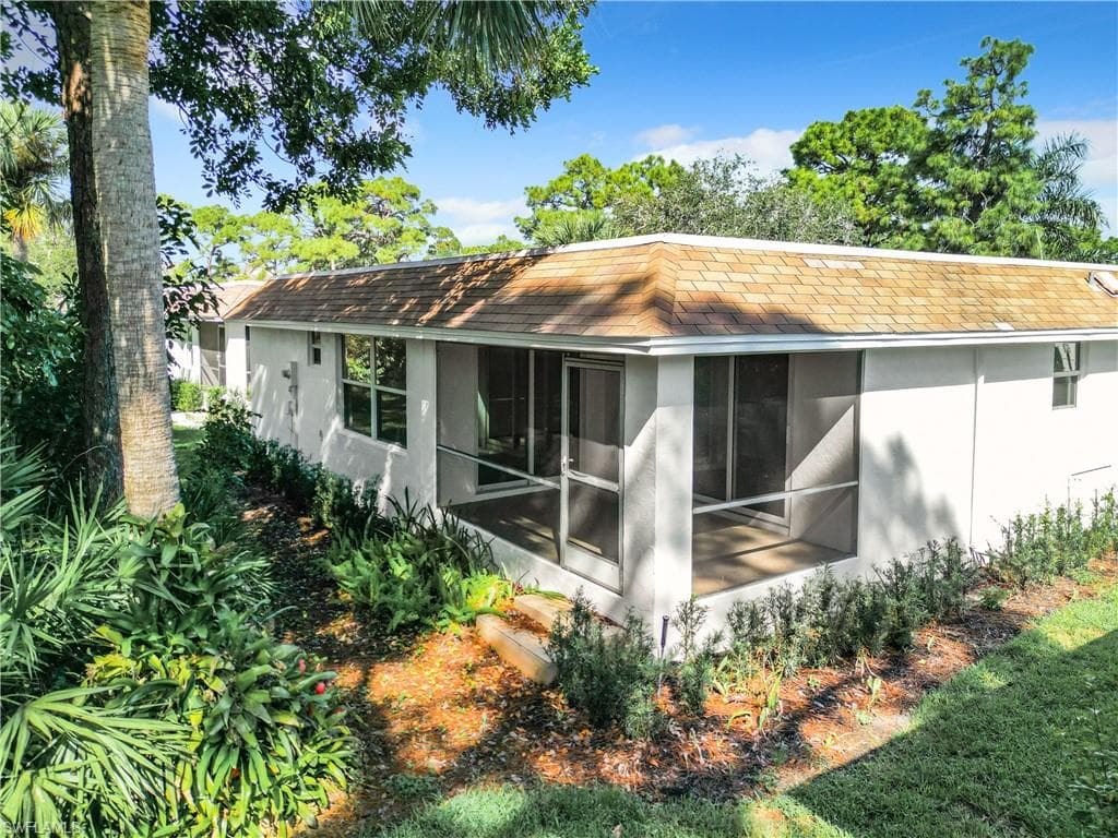 Rear view of house featuring a sunroom