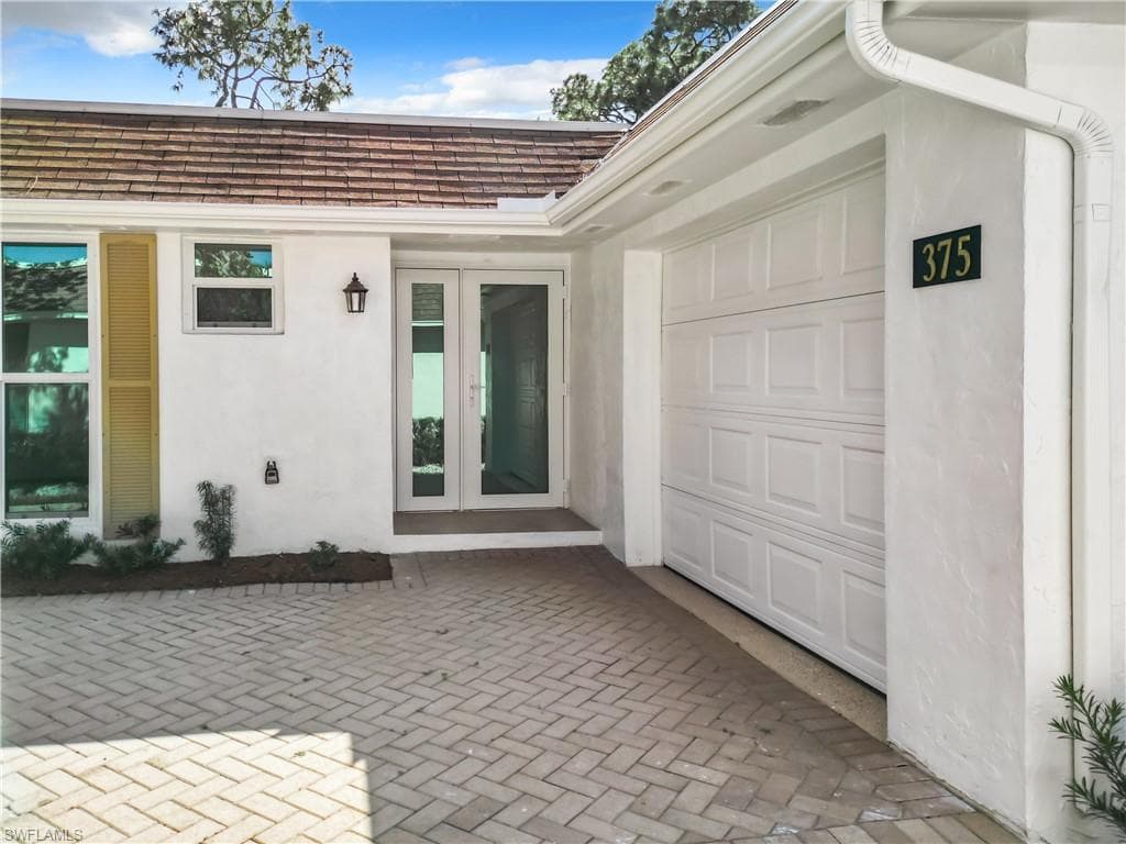 View of exterior entry with a garage