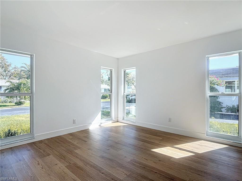 Unfurnished room featuring hardwood / wood-style flooring and plenty of natural light