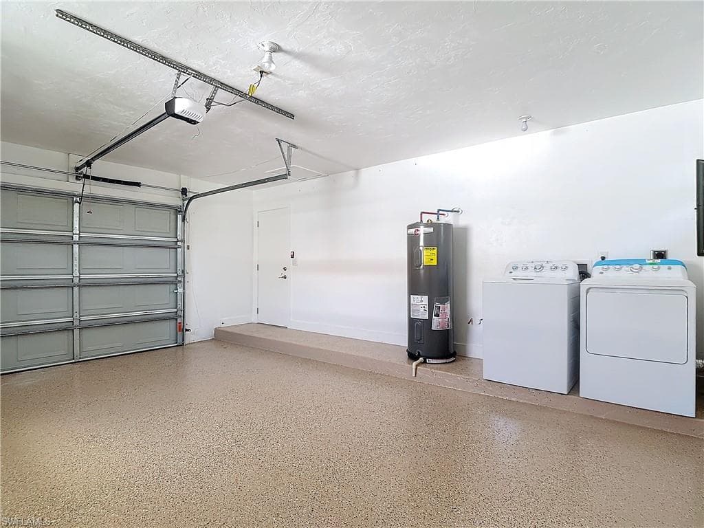 Garage with a garage door opener, independent washer and dryer, and electric water heater