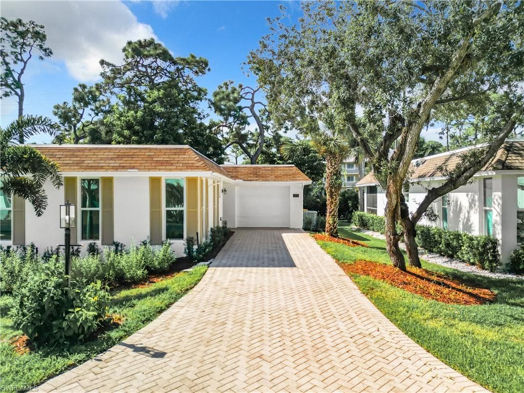 View of front of house with a front lawn and a garage