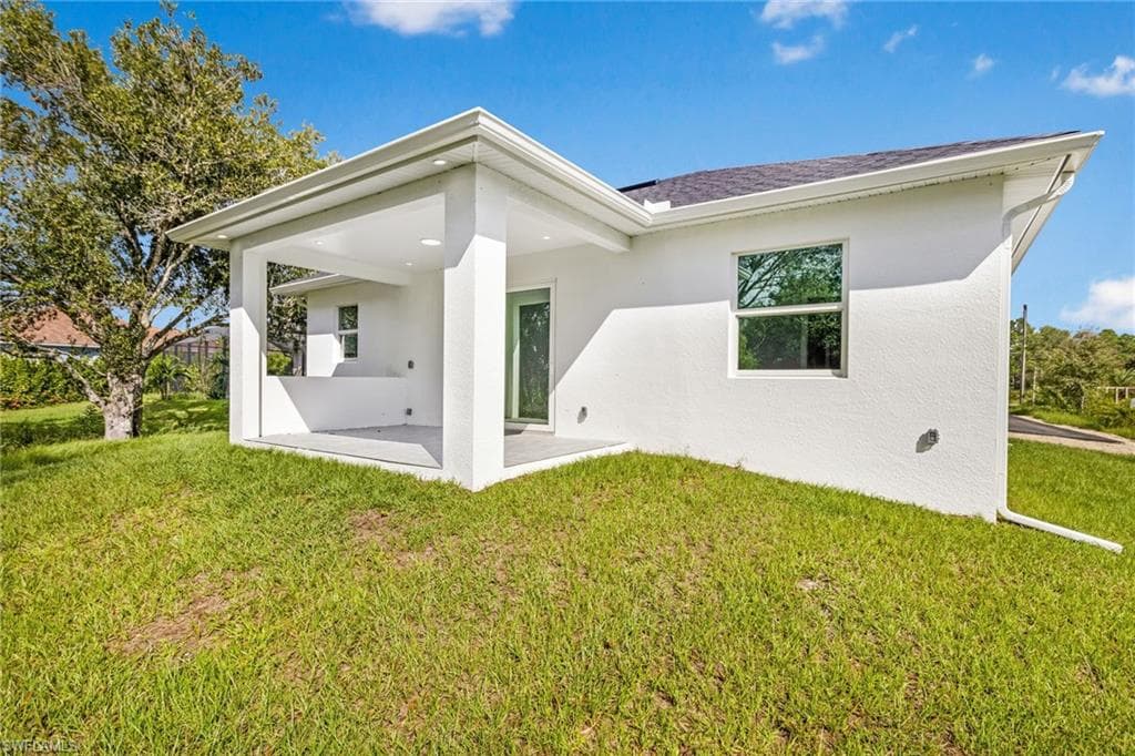 Rear view of property with a yard and a patio area