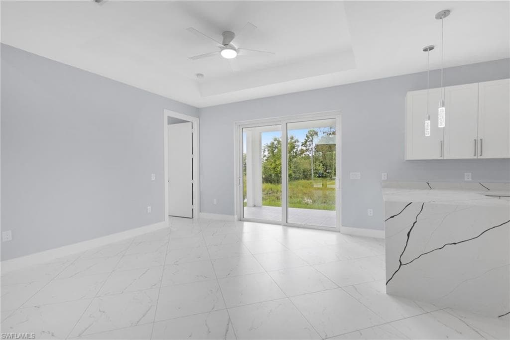 Living room with ceiling fan and a raised ceiling