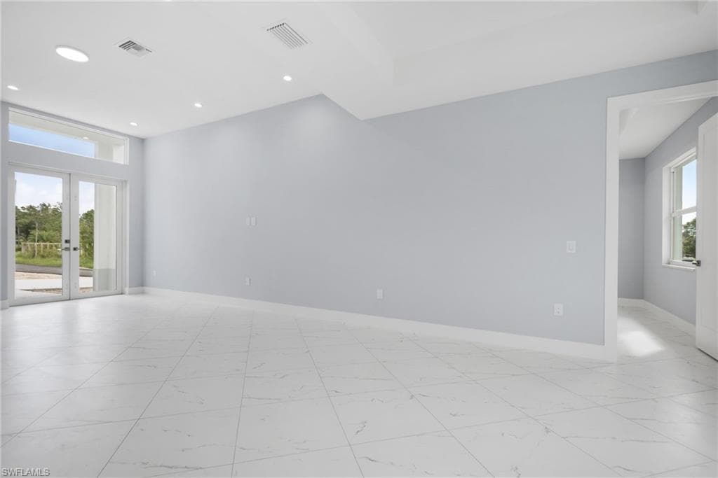 Unfurnished room featuring french doors and a healthy amount of sunlight