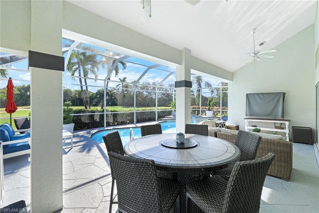 View of patio featuring ceiling fan and a lanai