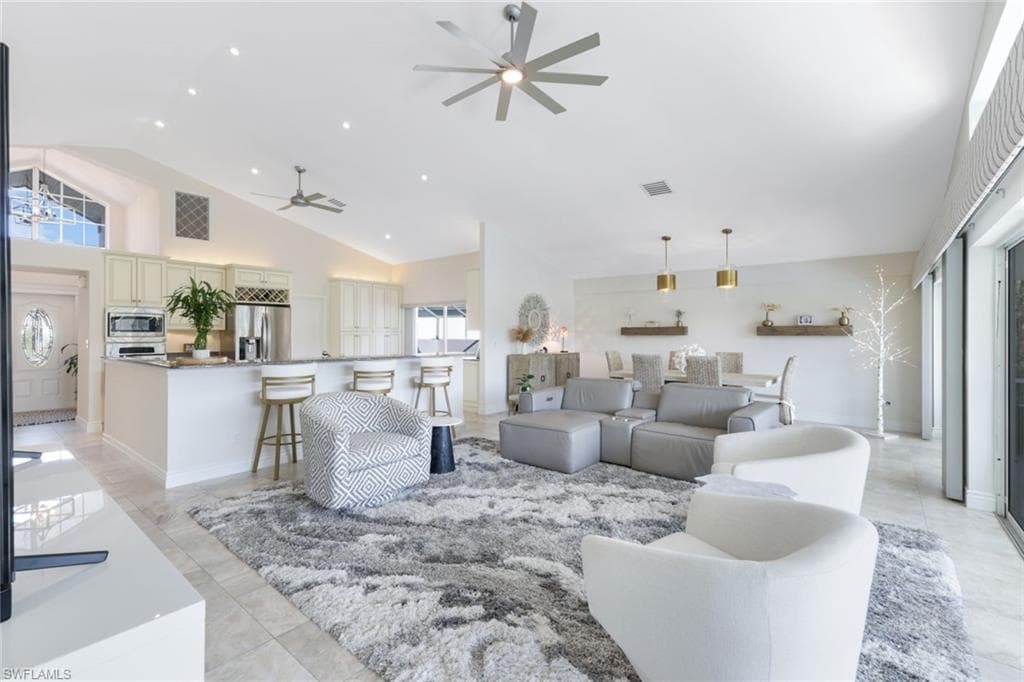 Tiled living room with high vaulted ceiling and ceiling fan