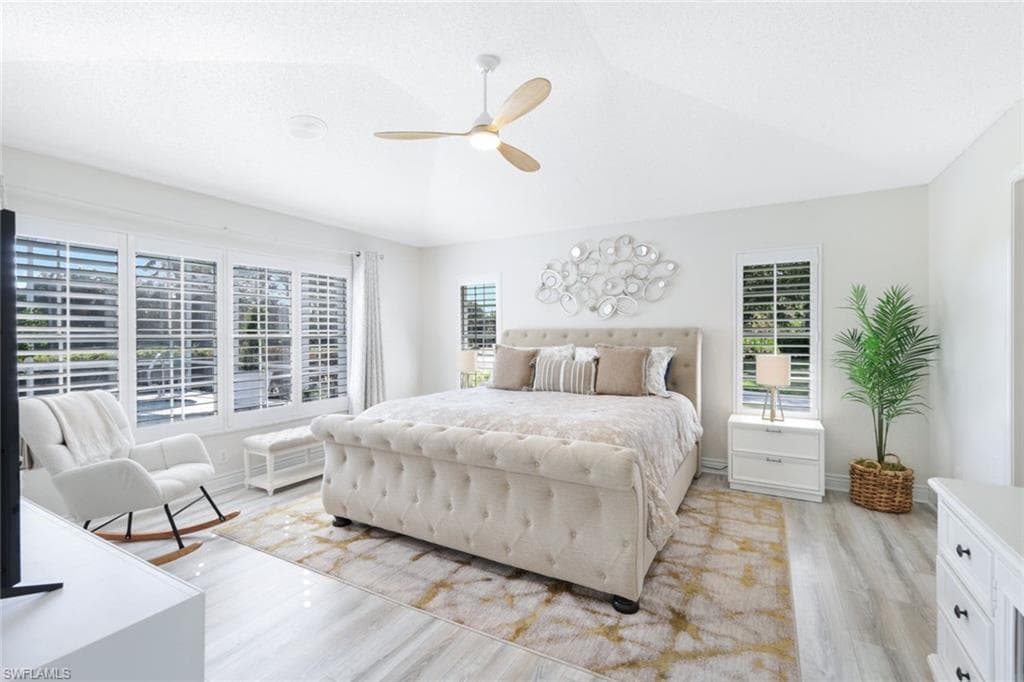 Bedroom featuring vaulted ceiling, light wood-type flooring, and ceiling fan