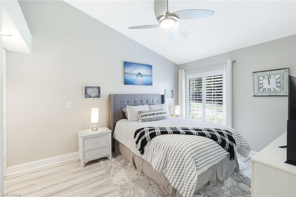 Bedroom with light hardwood / wood-style flooring, vaulted ceiling, and ceiling fan