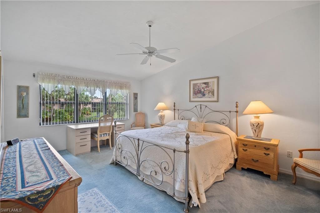 Carpeted bedroom with lofted ceiling and ceiling fan
