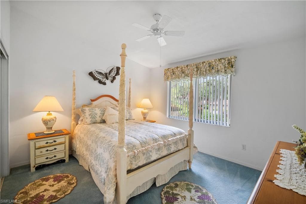 Bedroom with ceiling fan and dark colored carpet