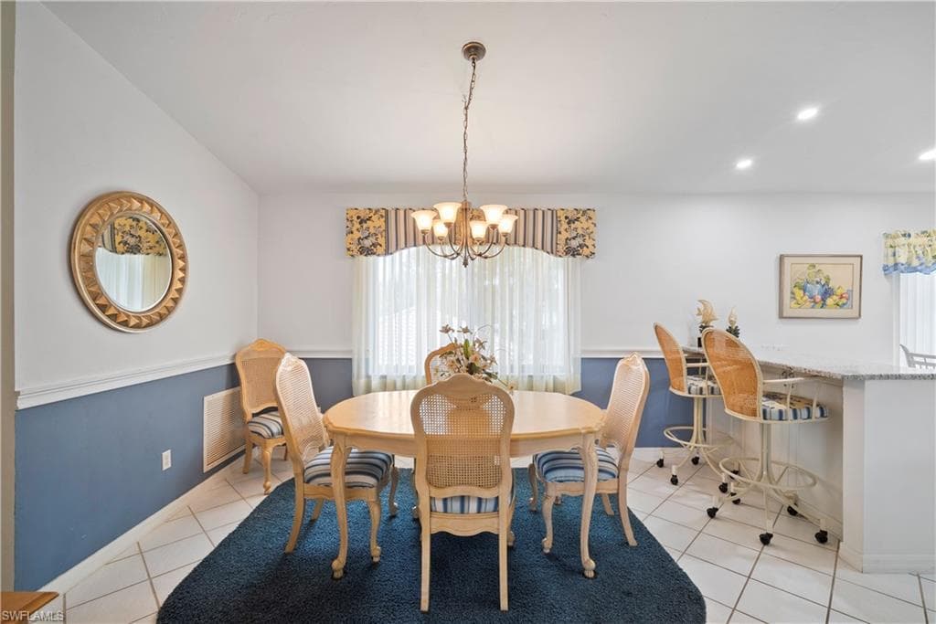 Tiled dining area featuring a chandelier