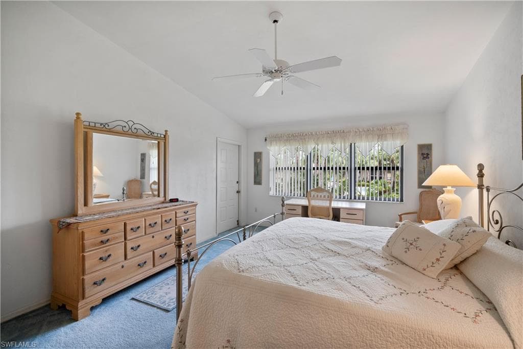 Bedroom featuring ceiling fan, carpet, and vaulted ceiling