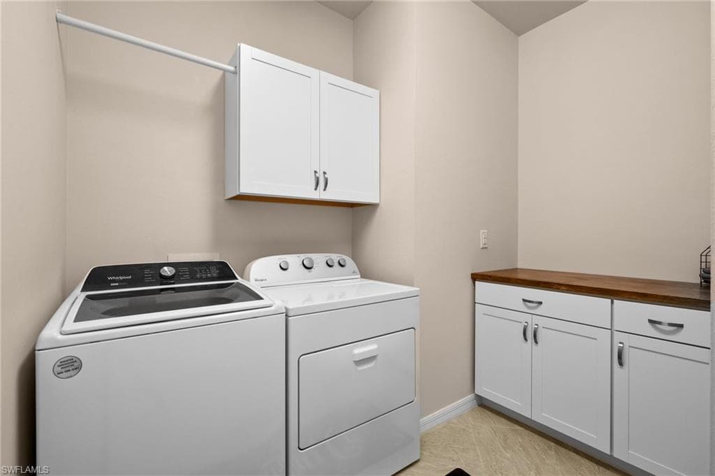 Laundry area featuring cabinets and independent washer and dryer