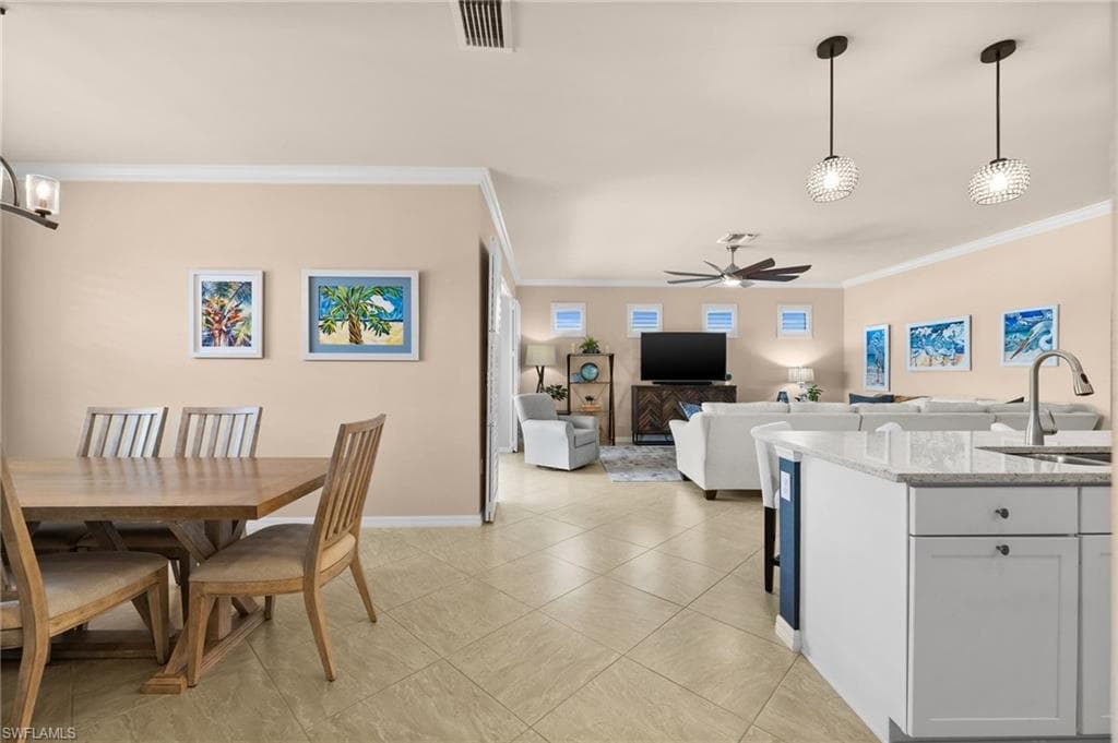 Dining room with ceiling fan, crown molding, and sink