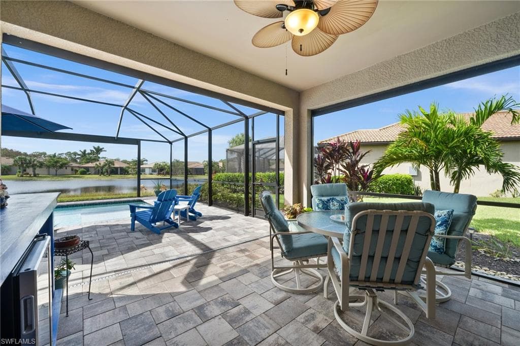 View of patio / terrace featuring ceiling fan, a water view, and glass enclosure