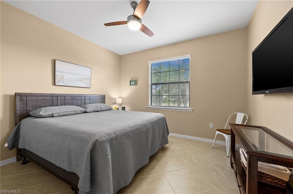 Tiled bedroom featuring ceiling fan