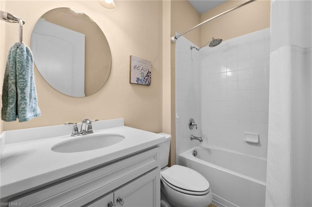 Full bathroom featuring vanity, toilet, and shower / bathtub combination with curtain