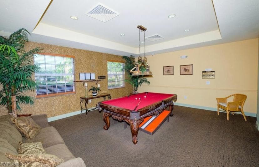 Rec room featuring dark colored carpet, billiards, and a raised ceiling