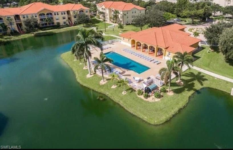 Birds eye view of property with a water view