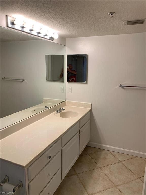 Bathroom featuring vanity, a textured ceiling, and tile patterned floors