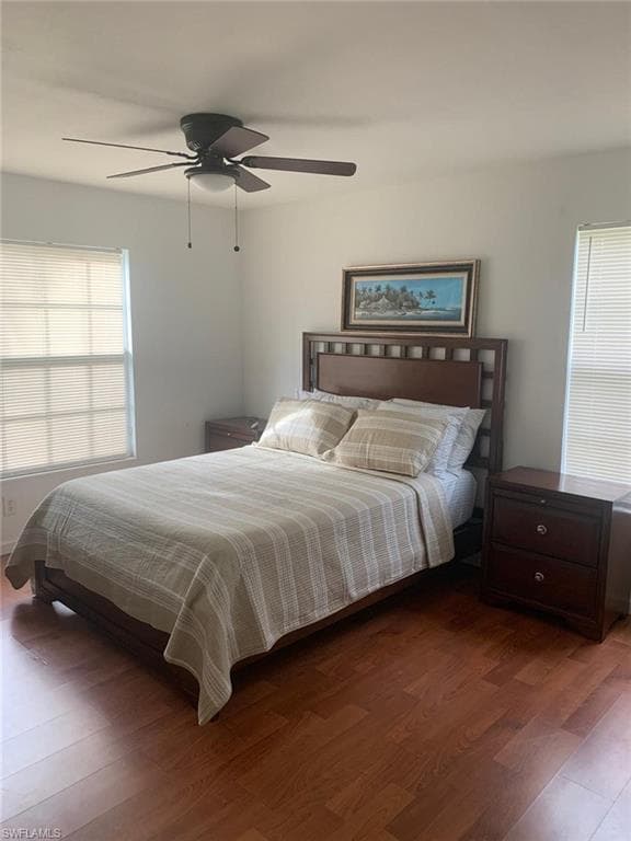 Bedroom with ceiling fan and dark hardwood / wood-style flooring