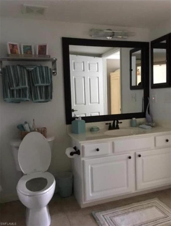 Bathroom with vanity, toilet, and tile patterned floors