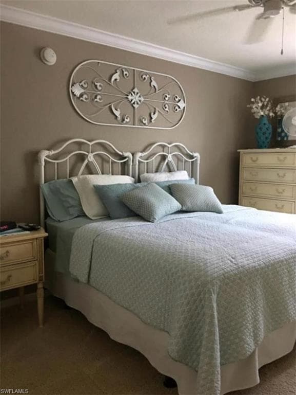 Bedroom with ornamental molding, carpet flooring, and ceiling fan