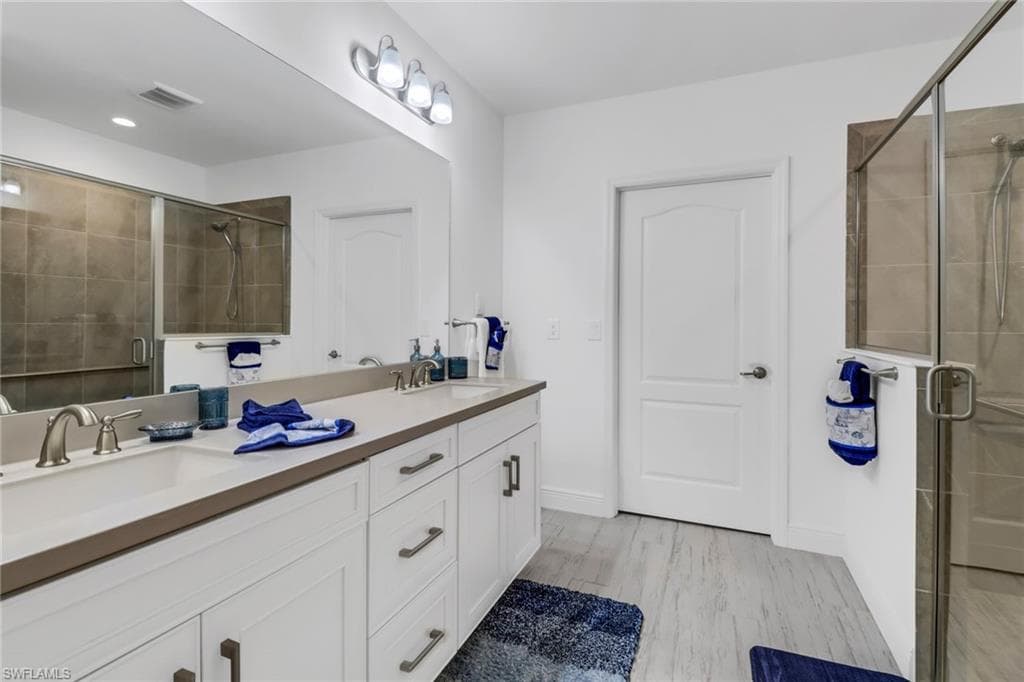 Bathroom with dual sinks and a shower