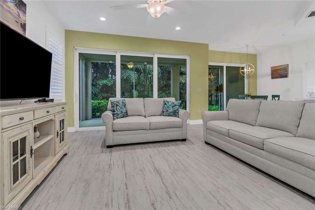 Living room with light wood tile flooring and ceiling fan