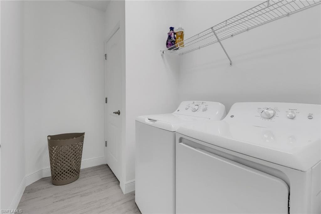 Laundry room with washer and dryer and light hardwood type tile