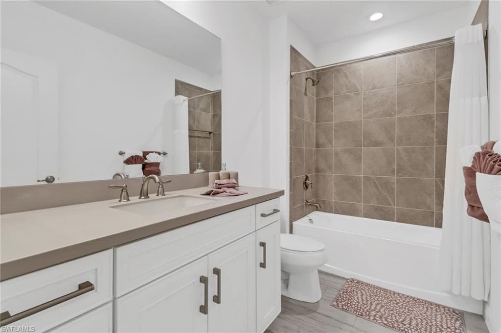 Full guest bathroom with vanity, toilet, shower / bathtub combination