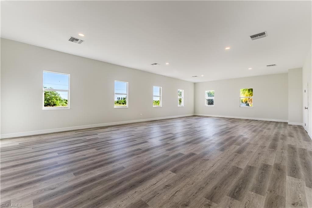 Unfurnished living room featuring recessed lighting, plenty of natural light, and wood finished floors