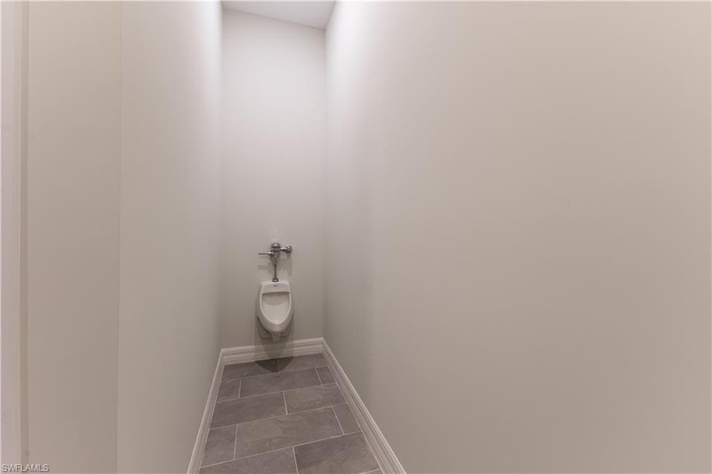 Bathroom with baseboards and light tile patterned flooring