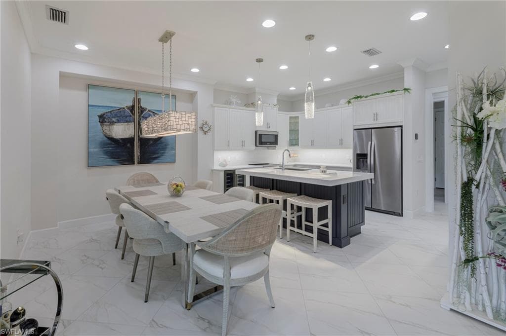 Dining area featuring crown molding and sink